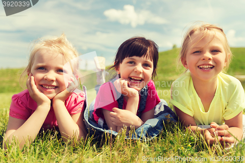 Image of group of kids lying on blanket or cover outdoors