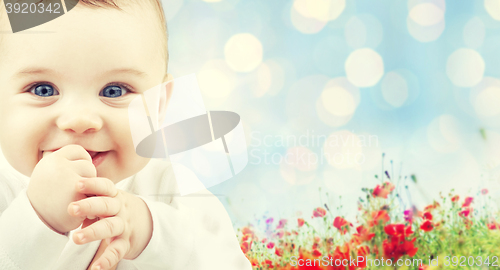 Image of beautiful happy baby over poppy field background