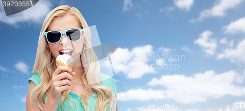 Image of happy young woman in sunglasses eating ice cream