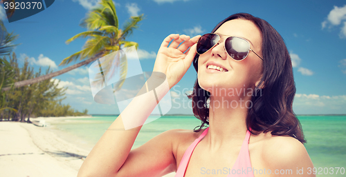 Image of happy woman in sunglasses and swimsuit