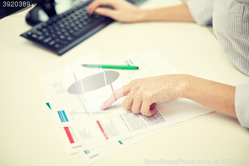 Image of close up of woman hands with papers and computer