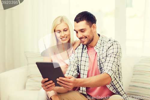 Image of smiling happy couple with tablet pc at home