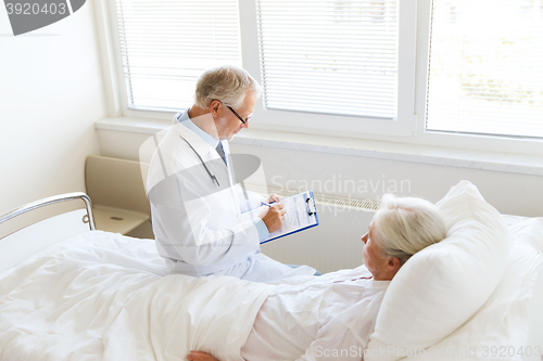 Image of senior woman and doctor with clipboard at hospital
