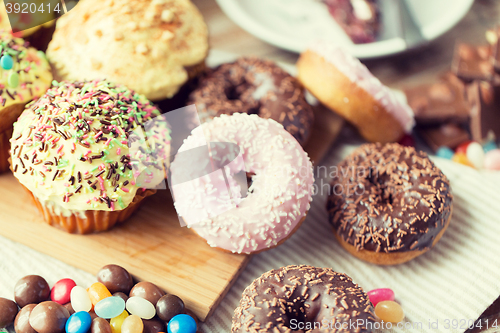 Image of close up of glazed donuts and sweets on table