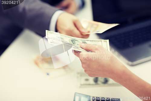 Image of close up of hands giving or exchanging money