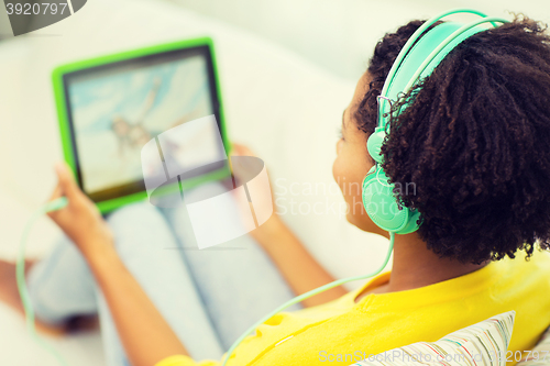 Image of happy african woman with tablet pc and headphones