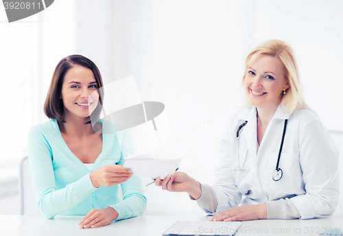 Image of doctor giving prescription to patient in hospital