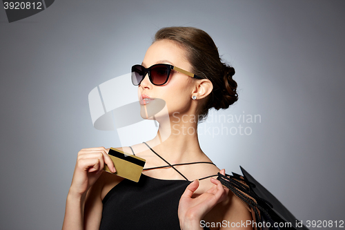 Image of happy woman with credit card and shopping bags