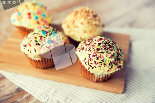 Image of close up of glazed cupcakes or muffins on table