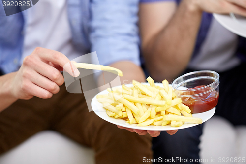 Image of close up of man with french fries and ketchup