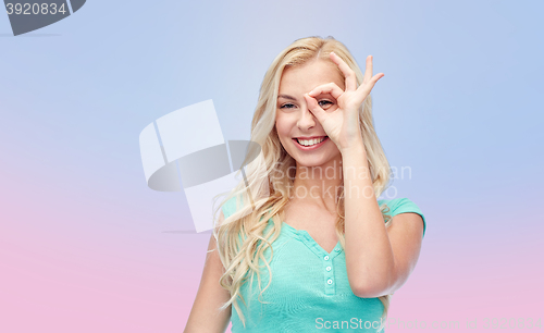 Image of young woman making ok hand gesture