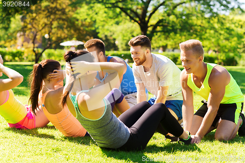 Image of group of friends or sportsmen exercising outdoors