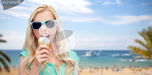 Image of happy young woman in sunglasses eating ice cream