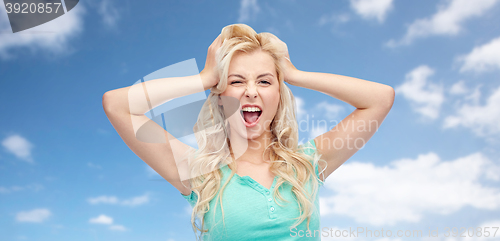 Image of smiling young woman holding to her head or hair