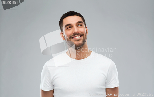 Image of smiling man looking up over gray background