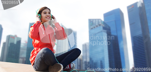 Image of happy young woman in headphones listening to music