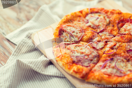 Image of close up of homemade pizza on wooden table