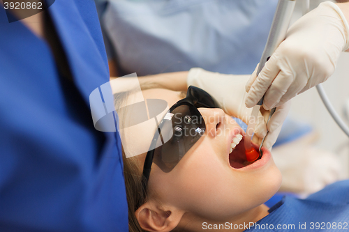 Image of female dentists treating patient girl teeth