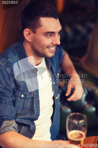 Image of happy man drinking beer at bar or pub