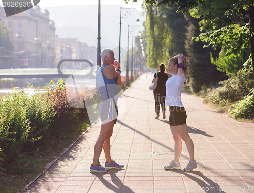 Image of couple warming up and stretching before jogging