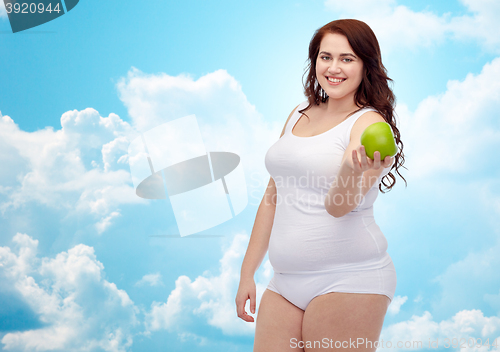 Image of happy plus size woman in underwear with apple