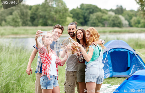 Image of happy friends taking selfie by smartphone at camp