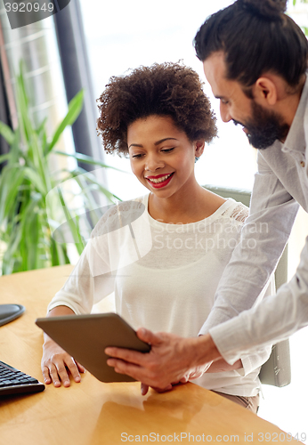 Image of happy creative team with tablet pc in office