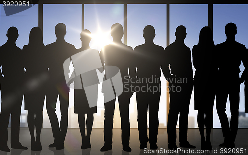 Image of business people silhouettes over office background