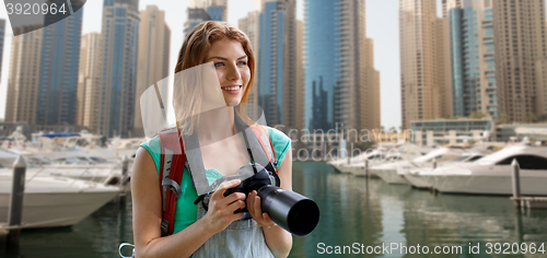 Image of woman with backpack and camera over dubai city