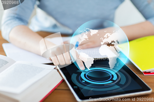 Image of close up of student with earth globe on tablet pc