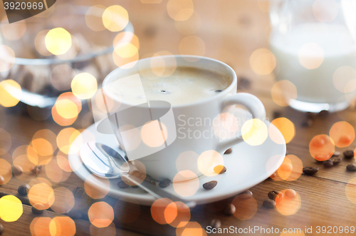 Image of close up coffee cup and grains on wooden table