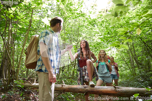 Image of group of smiling friends with backpacks hiking