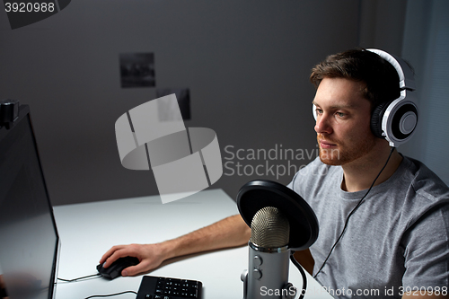 Image of man in headset playing computer video game at home