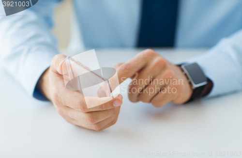 Image of close up of hands with smart phone and watch