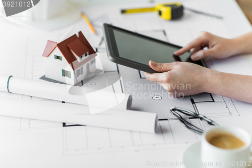 Image of close up of hand with blueprint and tablet pc