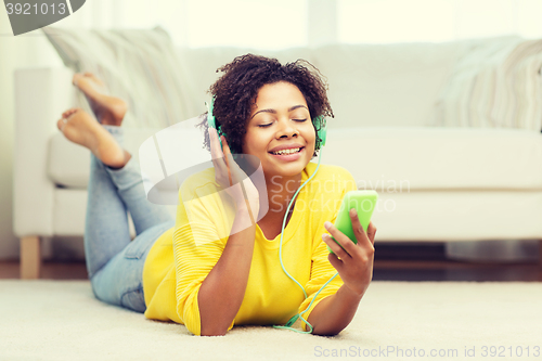 Image of happy african woman with smartphone and headphones