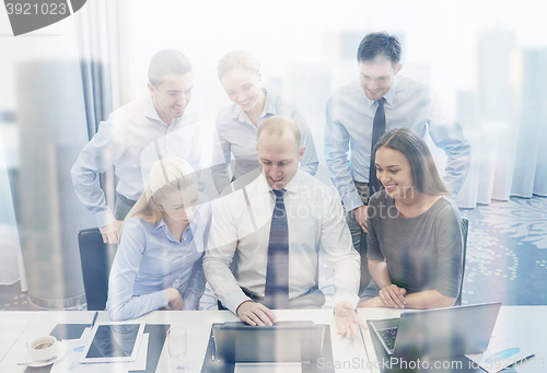 Image of smiling business people with laptop in office
