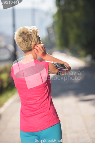 Image of jogging woman setting phone before jogging