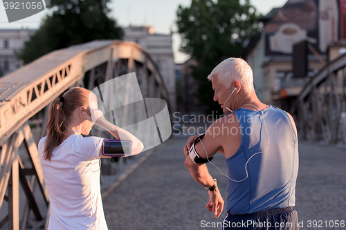 Image of jogging couple planning running route  and setting music