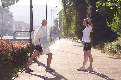 Image of couple warming up and stretching before jogging