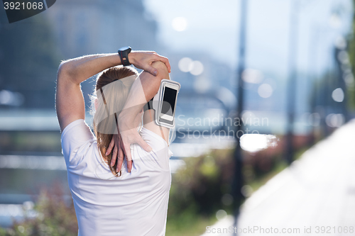 Image of blonde woman  stretching before morning jogging