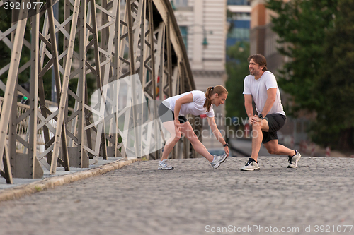 Image of couple warming up and stretching before jogging