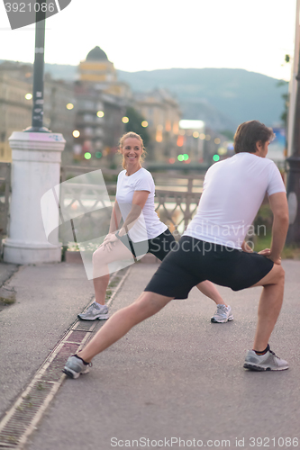 Image of couple warming up before jogging