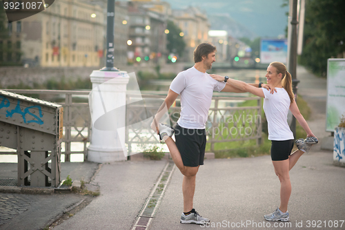 Image of couple warming up before jogging