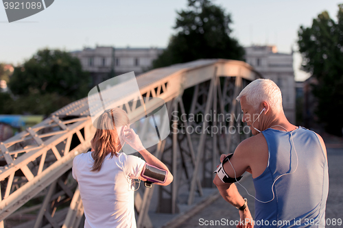 Image of jogging couple planning running route  and setting music