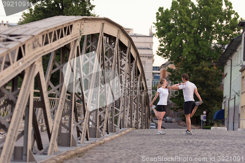 Image of couple warming up and stretching before jogging