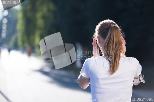 Image of jogging woman setting phone before jogging