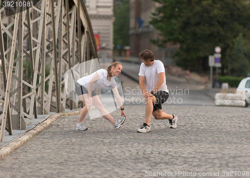 Image of couple warming up and stretching before jogging