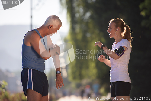 Image of jogging couple planning running route  and setting music