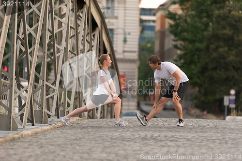 Image of couple warming up and stretching before jogging
